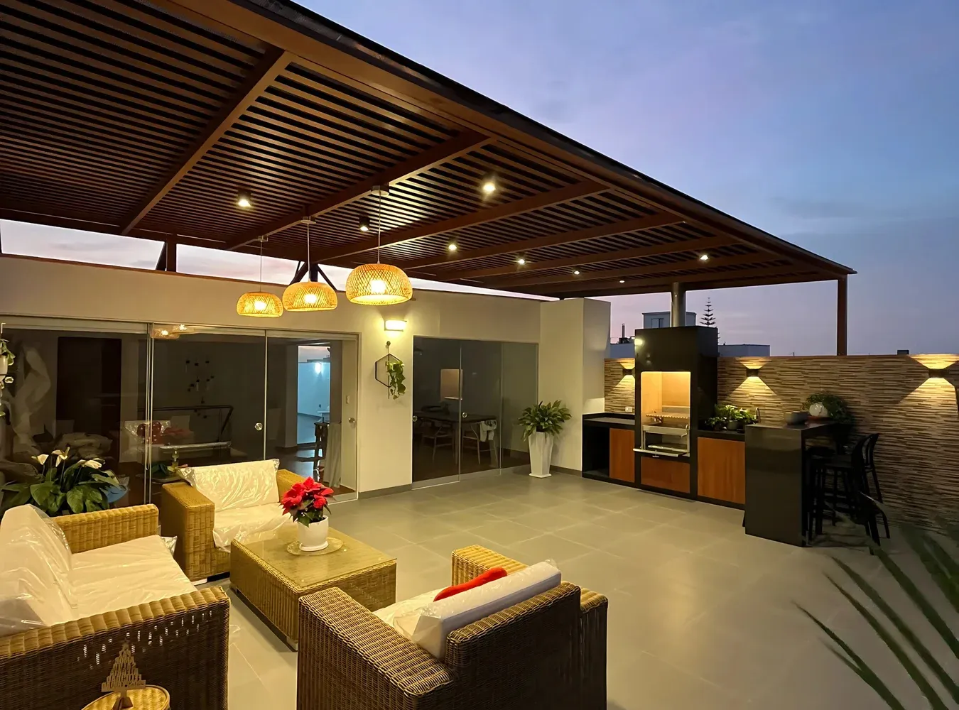 Terraza Martín Fierro iluminada al atardecer, con sala exterior y estación de parrilla
